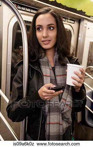 Woman using cell phone on subway View Large Photo Image Stock Photo - Woman using cell phone on subway. Fotosearch
