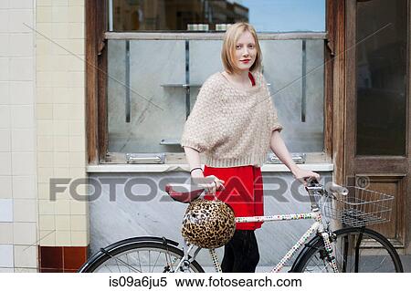 Stock Photography - Woman walking bicycle on city street. Fotosearch