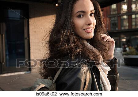 Stock Image - Woman walking on city street. Fotosearch