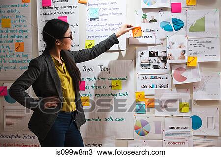 Woman with adhesive notes and papers on wall View Large Photo Image Stock Image - Woman with adhesive notes and papers on wall. Fotosearch