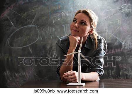 Stock Image - Woman with model wind turbine. Fotosearch