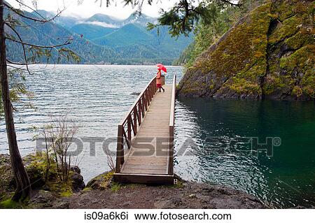 Woman with umbrella on wooden pier View Large Photo Image Stock Image - Woman with umbrella on wooden pier. Fotosearch