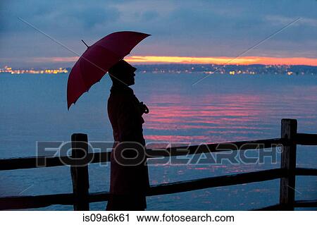 Woman with umbrella watching sunset View Large Photo Image Stock Image - Woman with umbrella watching sunset. Fotosearch