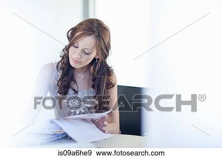 Stock Photo - Woman writing at desk. Fotosearch