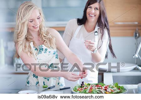 Stock Photo - Women cooking together in kitchen. Fotosearch
