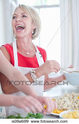 Stock Photo - Women cooking together in kitchen. Fotosearch