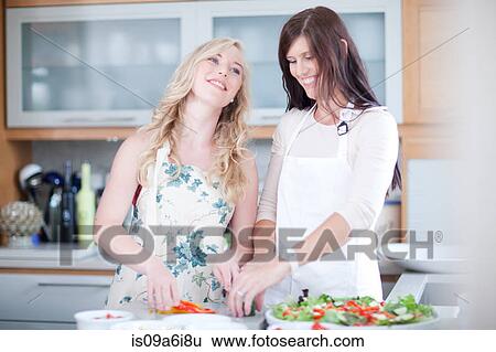 Women cooking together in kitchen View Large Photo Image Stock Photograph - Women cooking together in kitchen. Fotosearch