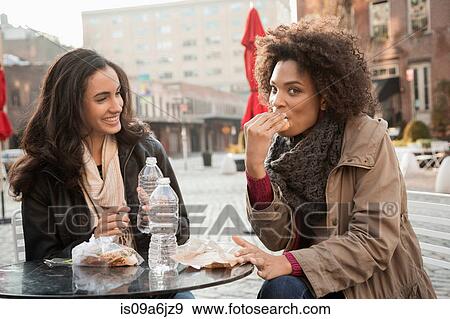 Stock Photo - Women eating together at sidewalk cafe. Fotosearch