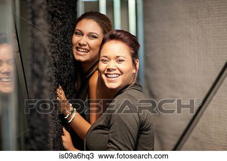 Stock Image - Women feeling carpet in store. Fotosearch