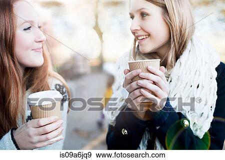 Stock Photo - Women having coffee together outdoors. Fotosearch