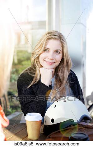 Stock Photo - Women having coffee together outdoors. Fotosearch