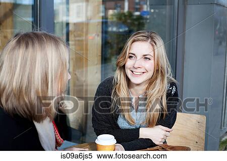Stock Photography - Women having coffee together outdoors. Fotosearch