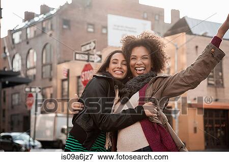 Stock Photo - Women hugging on city street. Fotosearch