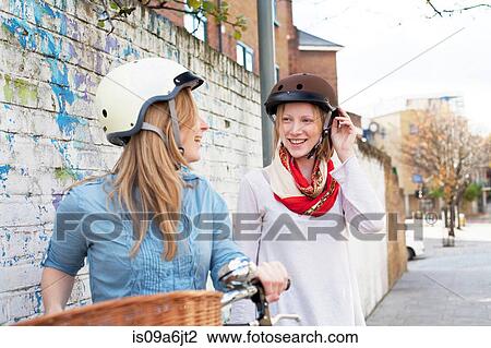 Women on bicycles on city street View Large Photo Image Stock Image - Women on bicycles on city street. Fotosearch