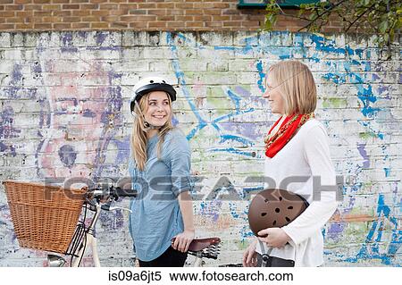 Women on bicycles on city street View Large Photo Image Stock Photography - Women on bicycles on city street. Fotosearch