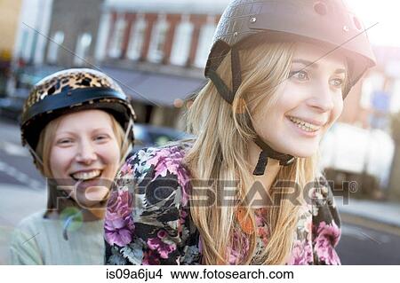 Picture - Women riding bicycle together. Fotosearch