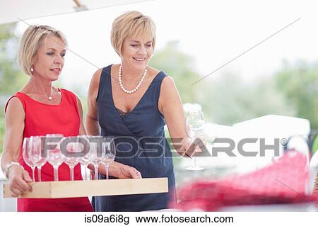 Women setting table outdoors View Large Photo Image Stock Image - Women setting table outdoors. Fotosearch