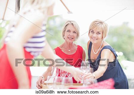 Women setting table outdoors View Large Photo Image Stock Image - Women setting table outdoors. Fotosearch