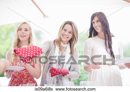 Stock Photograph - Women setting table outdoors. Fotosearch