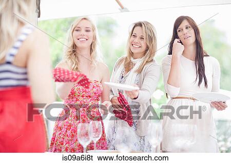 Stock Photograph - Women setting table outdoors. Fotosearch