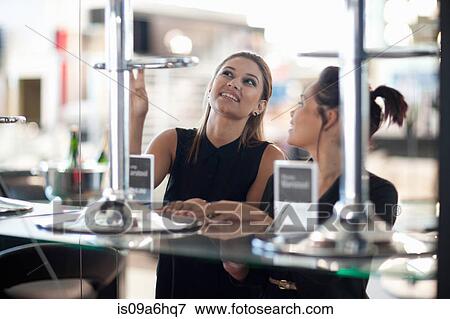 Stock Photo - Women shopping for chairs in store. Fotosearch