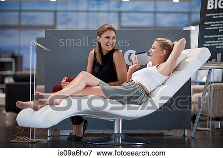 Stock Photo - Women shopping for furniture in store. Fotosearch