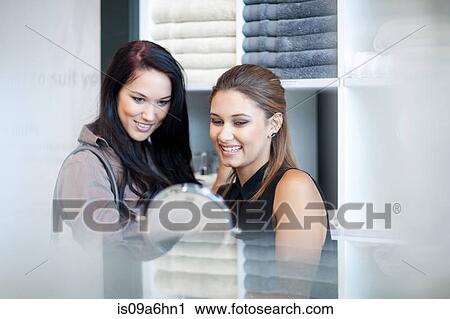 Stock Image - Women shopping for towels in store. Fotosearch
