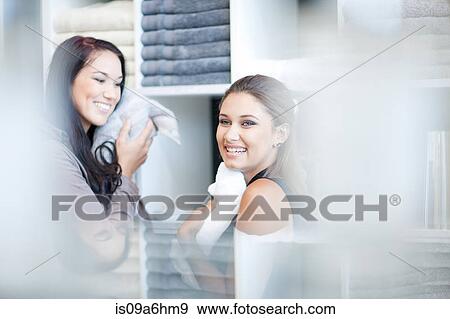 Stock Photo - Women shopping for towels in store. Fotosearch