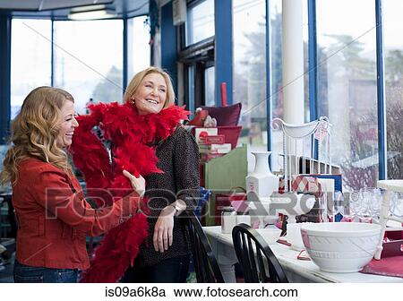Stock Image - Women shopping in thrift store. Fotosearch