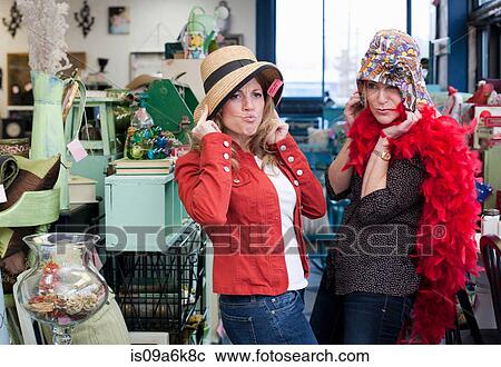 Stock Image - Women shopping in thrift store. Fotosearch