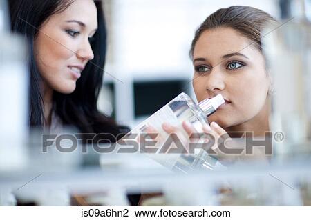 Stock Image - Women smelling soap in store. Fotosearch