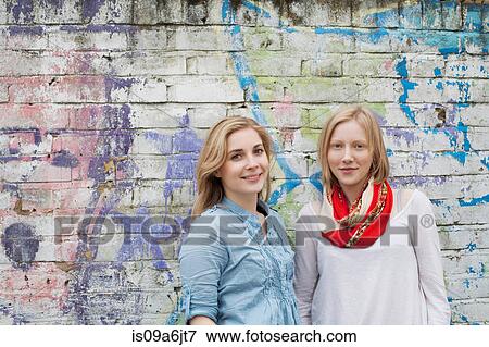 Women smiling by brick wall View Large Photo Image Stock Photo - Women smiling by brick wall. Fotosearch