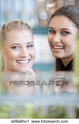 Stock Image - Women smiling together in store. Fotosearch