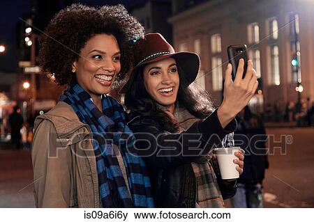 Stock Photo - Women taking cell phone picture. Fotosearch