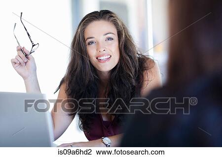 Stock Image - Women talking at desk. Fotosearch