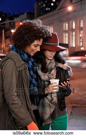Stock Photo - Women using cell phone on city street. Fotosearch
