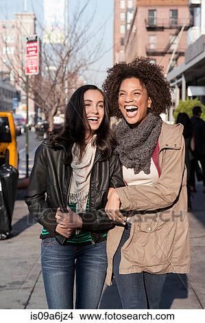 Picture - Women walking together on city street. Fotosearch