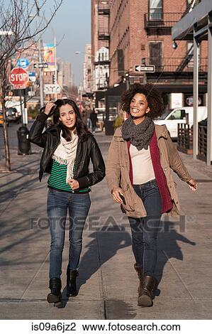Stock Image - Women walking together on city street. Fotosearch