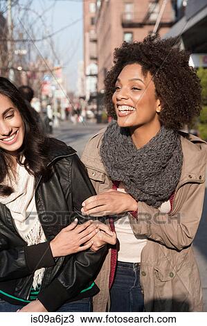 Stock Image - Women walking together on city street. Fotosearch