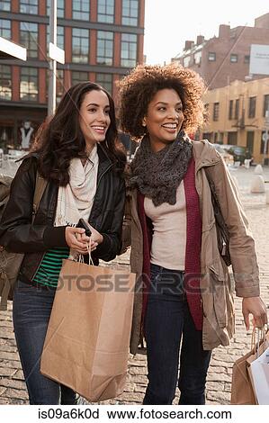 Women walking together on city street View Large Photo Image Stock Image - Women walking together on city street. Fotosearch