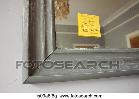 Stock Image - Adhesive note on mirror saying 'don't forget to pay the mortgage'. Fotosearch