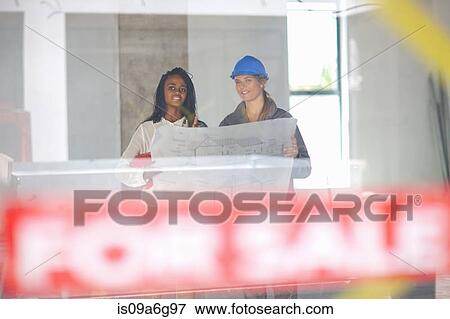 Architect and construction worker discussing blueprint on construction site View Large Photo Image Stock Photo - Architect and construction worker discussing blueprint on construction site. Fotosearch