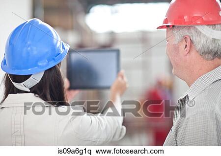 Back view of co-workers looking at digital tablet on construction site View Large Photo Image Stock Photography - Back view of co-workers looking at digital tablet on construction site. Fotosearch