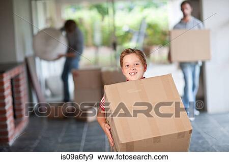 Boy moving house carrying cardboard box View Large Photo Image Stock Photo - Boy moving house carrying cardboard box. Fotosearch