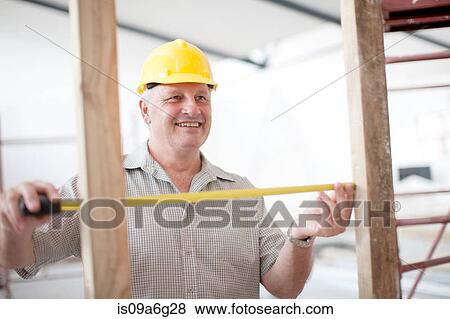Builder measuring construction frame View Large Photo Image Stock Photo - Builder measuring construction frame. Fotosearch