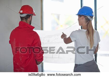 Building contractor and project manager looking at blueprint View Large Photo Image Picture - Building contractor and project manager looking at blueprint. Fotosearch