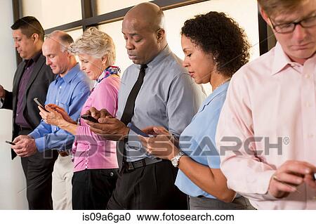Stock Image - Business colleagues using cell phones. Fotosearch
