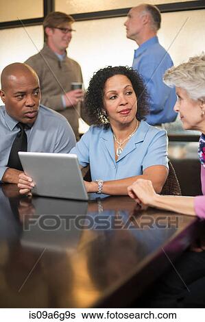 Business colleagues using digital tablet View Large Photo Image Stock Photograph - Business colleagues using digital tablet. Fotosearch