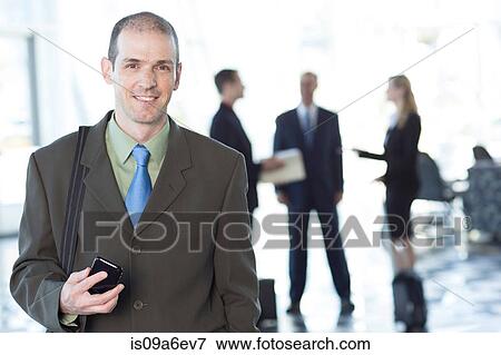 Stock Photo - Businessman holding cell phone. Fotosearch