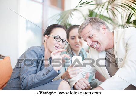 Stock Image - Businesspeople using smartphone. Fotosearch